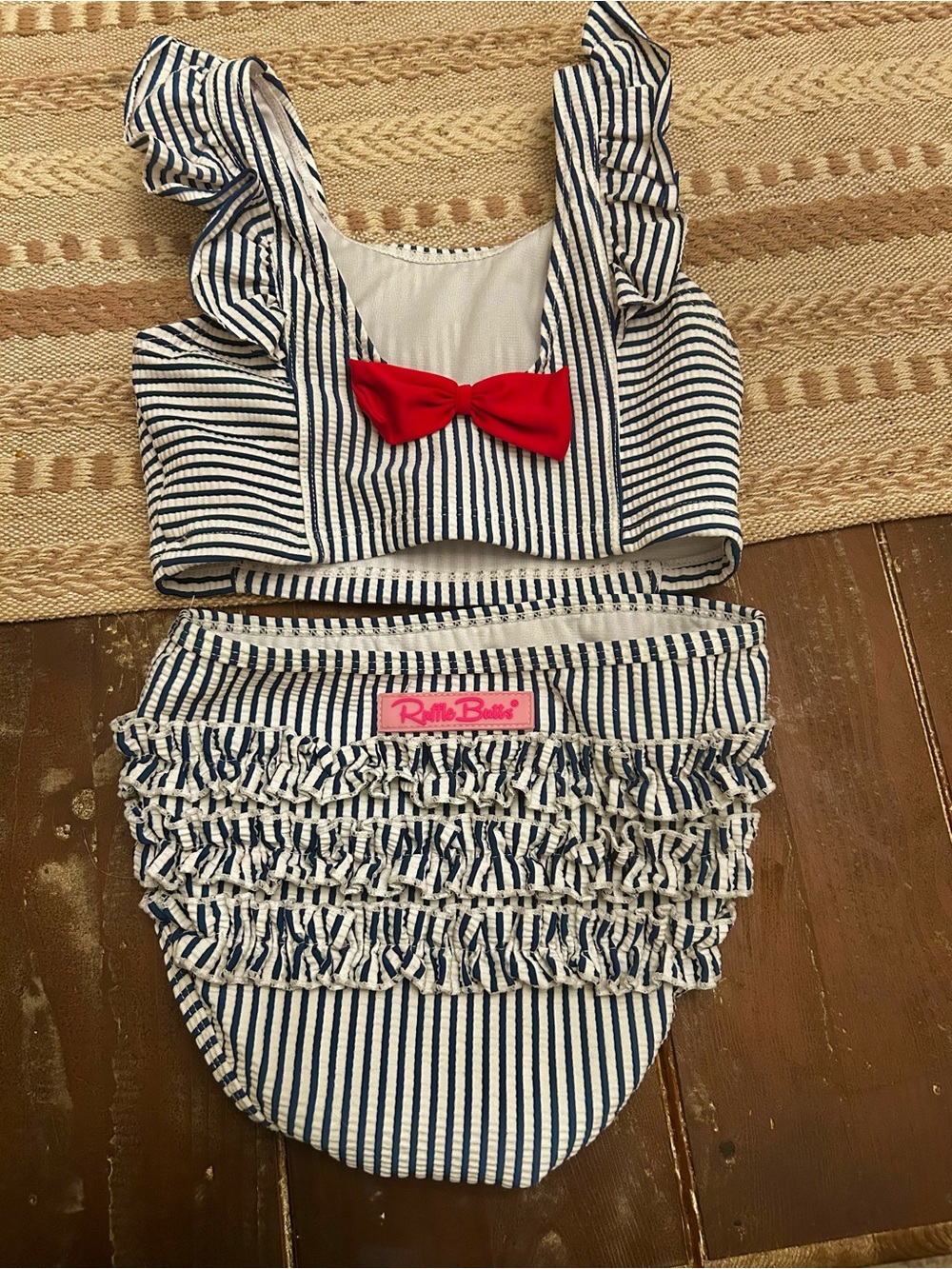 Ruffle Butts Navy and White Striped Ruffle Bikini Top with Pink Logo Tag